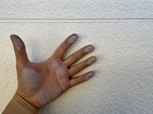 白い粉がつくチョーキング現象を確認している様子