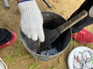 バケツの中で塗料を丁寧に混ぜ合わせる下準備