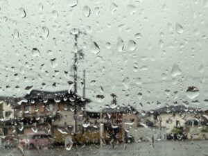 窓に映る風景と雨粒